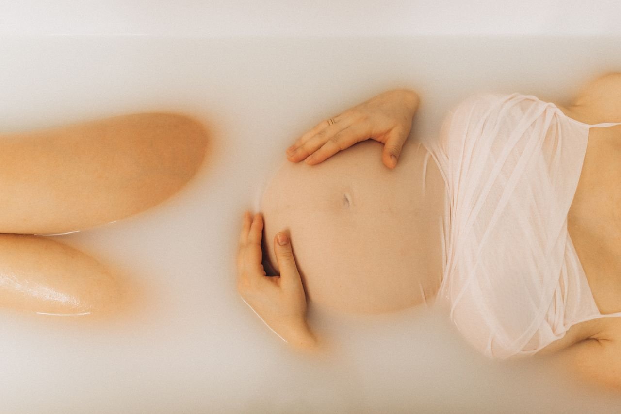 A pregnant woman enjoys a soothing milk bath, embracing maternity and relaxation.